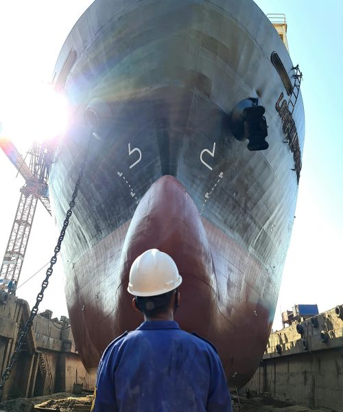Shipbuilding workers assembling a vessel hull